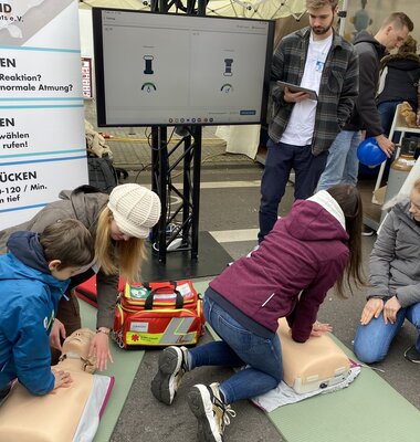 Studierende leiten Besucher zur Reanimation an speziellen &Uuml;bungspuppen an