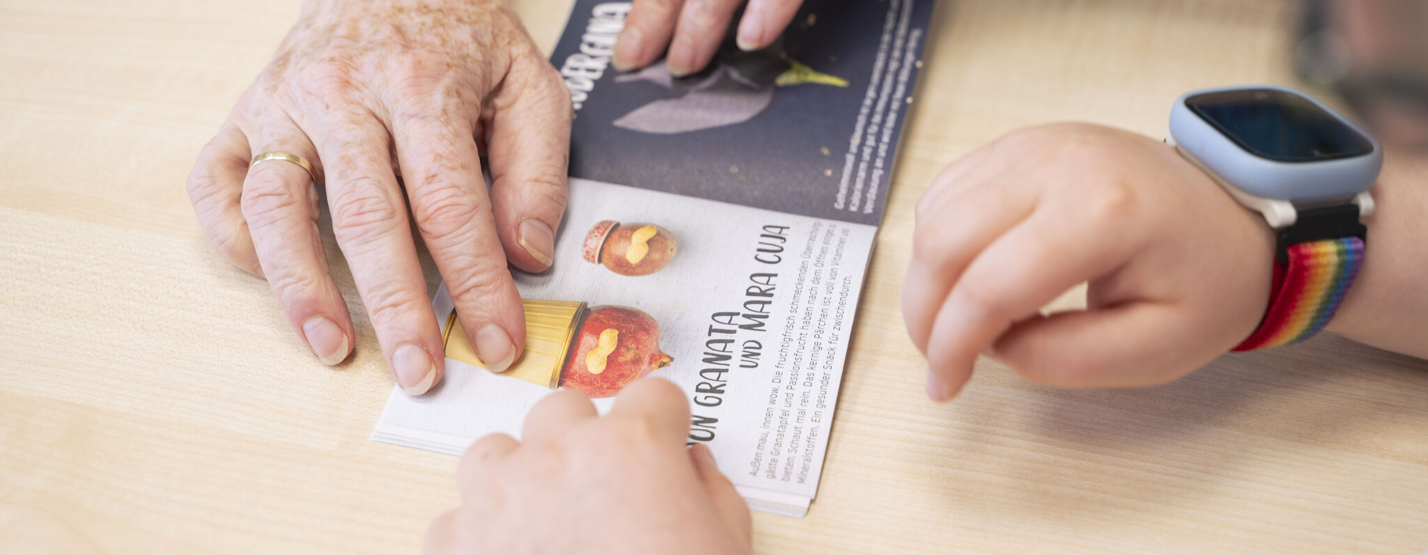 Zwei Handpaare beim Durchbl&auml;ttern eines kleines Flyers