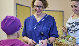 Pflegekr&auml;fte &uuml;bergeben ein Geschenk an eine Patientin