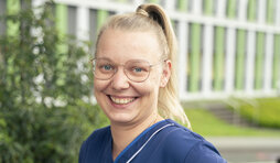 Pflegefachkraft vor Klinikgeb&auml;ude