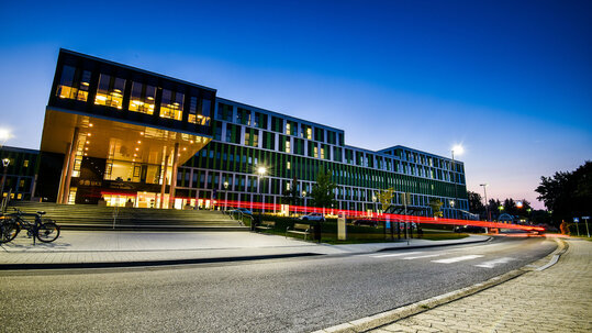 N&auml;chtliche Au&szlig;enaufnahme der IMED-Fassade mit Haupteingang