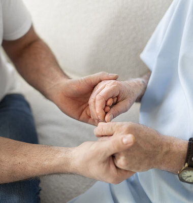 Parkinsonpatient h&auml;lt Hand einer Angeh&ouml;rigen