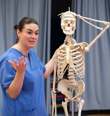 Eine Physiotherapeutin veranschaulicht die Anatomie des menschlichen K&ouml;rpers